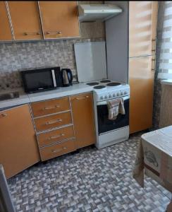 a kitchen with a stove and a microwave at Apartment near the airport - Квартира около аэропорта in Dushanbe
