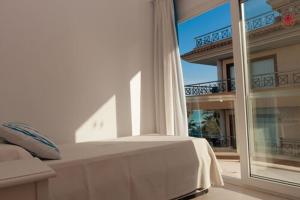 a bedroom with a bed and a large window at Arcadia in Cala Millor