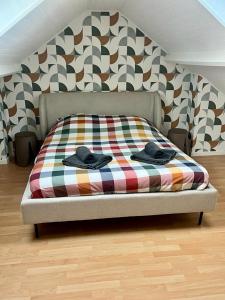 a bed with a plaid blanket on top of it at Un cocon entre ville et nature in Annappes