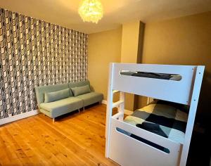 1 dormitorio con litera y sofá en Un cocon entre ville et nature en Annappes