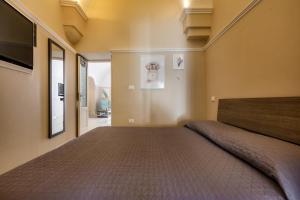 a bedroom with a large bed and a flat screen tv at Appartamento Leonard by BarbarHouse in Carovigno