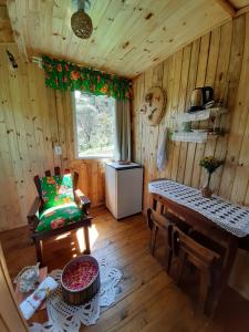 um quarto com uma mesa e um banco numa cabina em Chalé Refúgio das Águas em Urupema