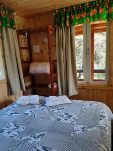 a bedroom with a bed and two bunk beds at Chalé Refúgio das Águas in Urupema