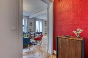 a hallway with a red wall and a dining room at Dans les arbres à Montmartre in Paris
