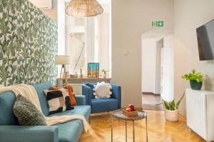 a living room with a blue couch and a table at Sleeping in Krakow Main Market in Kraków