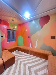 a living room with a couch and a colorful wall at 3 Raahi in Udaipur