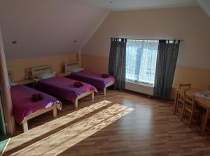 a room with two beds and a table and a window at Arsenal in Daugavpils