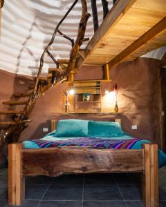 una camera da letto con letto in legno in mansarda di DOMOS PUJLLAI San Pedro de Atacama a San Pedro de Atacama