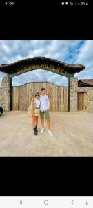 a man and a woman standing in front of a gate at Rainbow house in Boma la Ngombe