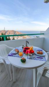 - une table blanche avec de la nourriture sur le balcon dans l'établissement Paraíso Para Todos, à Mogán