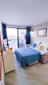 1 dormitorio con 1 cama azul y 1 sofá en Paraíso Para Todos, en Mogán
