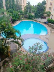 een groot zwembad in een tuin met een palmboom bij 2 Bedroom KMA Mtwapa Estate in Mtwapa