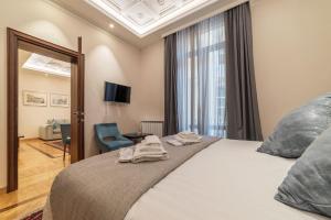 um quarto com uma cama, uma cadeira e uma janela em 900 Apartments Veneto & Pinciana em Roma