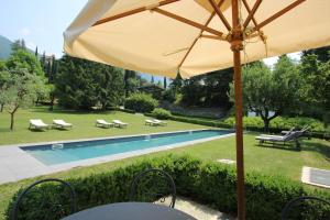 a yellow umbrella sitting next to a swimming pool at Castello di Vezio in the Village in Varenna