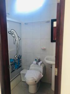 baño con un delfín pintado en la pared en Hostal Las Fragatas, en Puerto Villamil