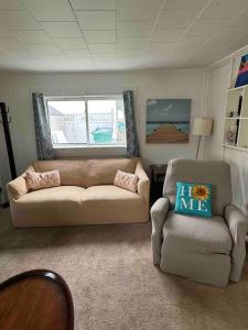 een woonkamer met een bank en een stoel bij Beach Cottage on North Beach in Hampton