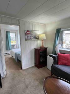 een woonkamer met een bed, een bank en een tafel bij Beach Cottage on North Beach in Hampton