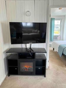 a living room with a flat screen tv and a fireplace at Beach Cottage on North Beach in Hampton