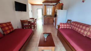 a living room with red couches and a table at Captain's House in Sivota