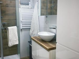 La salle de bains est pourvue d'un lavabo blanc et d'une douche. dans l'établissement Noclegi Wrzosowa Grabianów, à Grabianów