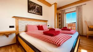 a bedroom with a bed with red pillows on it at Bio Alpenhof Rostatt in Bischofshofen