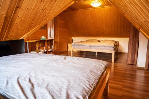 1 dormitorio con 2 camas en un ático de madera en Chata Východná, en Východná