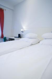 1 Schlafzimmer mit 2 weißen Betten und einem Schreibtisch in der Unterkunft AP Hotel Viernheim Mannheim am Kapellenberg in Viernheim