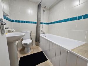 W łazience znajduje się toaleta, wanna i umywalka. w obiekcie Littlewood Gardens Escapes, Ideal Retreats with Green Views- Ideal Summer Stays w Liverpoolu