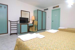 ein Hotelzimmer mit 2 Betten und einem TV in der Unterkunft Villaggio Club Baia Dei Gigli in Casa dello Stumio