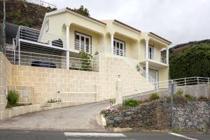 a large building with a stone wall and stairs at UP THE HILL, Conforto e bem estar in Ponta do Sol