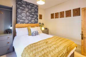 ein Schlafzimmer mit einem großen Bett und einer gelben Decke in der Unterkunft Host & Stay - Ethelbert Cottage in Broadstairs