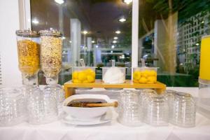 un groupe de bocaux en verre sur un comptoir avec une table avec des citrons dans l'établissement Hotel Theoxenia, à Mesolongion