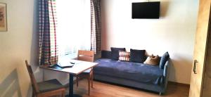 ein Wohnzimmer mit einem blauen Sofa und einem Tisch in der Unterkunft Haus Sonnleitn in Altenmarkt im Pongau