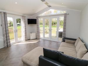 a living room with a couch and sliding glass doors at Coverdale Large Pod in Yarm