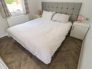 a bedroom with a large white bed and a window at Coverdale Large Pod in Yarm