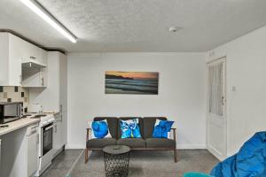 a living room with a couch and a kitchen at Finest Retreats - Atherfield Apartments No 4 - Lawn Side in Paignton