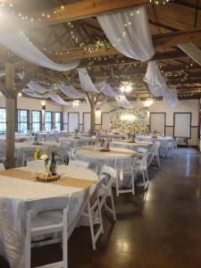 a banquet hall with white tables and white chairs at Canyon Lake Cabins in Canyon Lake