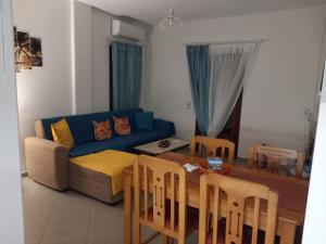 a living room with a blue couch and a table at Αγ Νικόλαος Karthaia in Elliniká