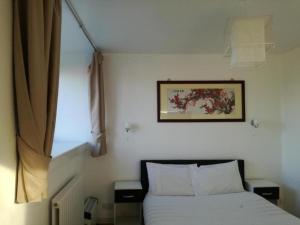 ダイスにあるArdenlea House Hotel B&bのベッドルーム1室(ベッド1台付)が備わります。壁に絵が飾られています。