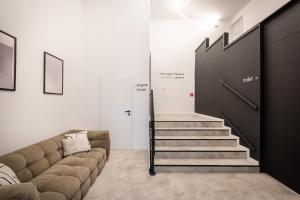 - un salon avec un canapé et un escalier dans l'établissement You Boutique Suites, Best Location by BQA, à Budapest