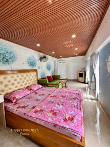 a bedroom with a bed with a pink comforter at Căn Funny in Vung Tau