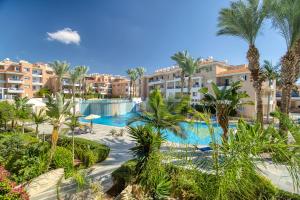 a resort with a swimming pool and palm trees at Iris Village Block 12-105 in Paphos