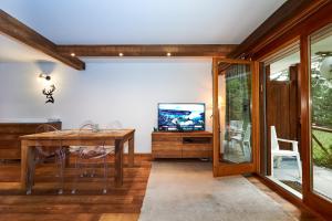 comedor con mesa y TV en Residence Tsaumiau, 2 bedrooms, ski lift 170m! en Crans-Montana
