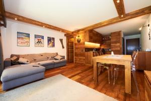 sala de estar con sofá y mesa en Residence Tsaumiau, 2 bedrooms, ski lift 170m! en Crans-Montana