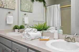 - une salle de bains avec 2 lavabos et des serviettes sur un comptoir dans l'établissement Deluxe Paradise - 3 King Beds + Fast Wifi + FREE Parking, 