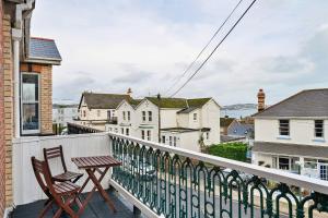 a balcony with a wooden table and chairs on it at Finest Retreats - Atherfield Apartments No 5 - Sea Views in Paignton