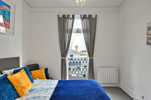 a bedroom with a bed with blue and orange pillows at Finest Retreats - Atherfield Apartments No 5 - Sea Views in Paignton