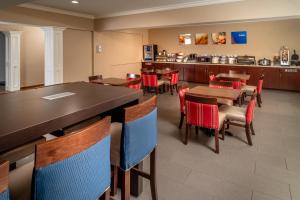 a dining room with tables and red chairs at Comfort Suites Prestonsburg West in Prestonsburg