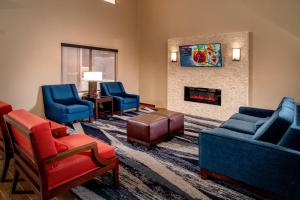 sala de estar con sillas azules y chimenea en Comfort Suites Prestonsburg West, en Prestonsburg