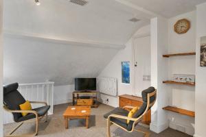 a living room with two chairs and a tv at Finest Retreats - Atherfield Apartments No 8 - Roof Tops in Paignton